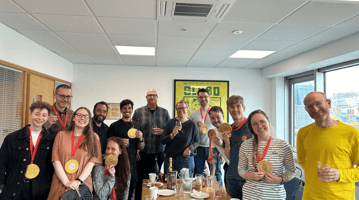 The participants posing for a photo with large gold medals