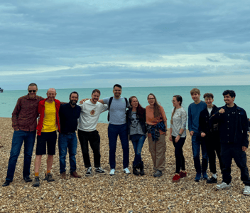 The participants posing together on the beach