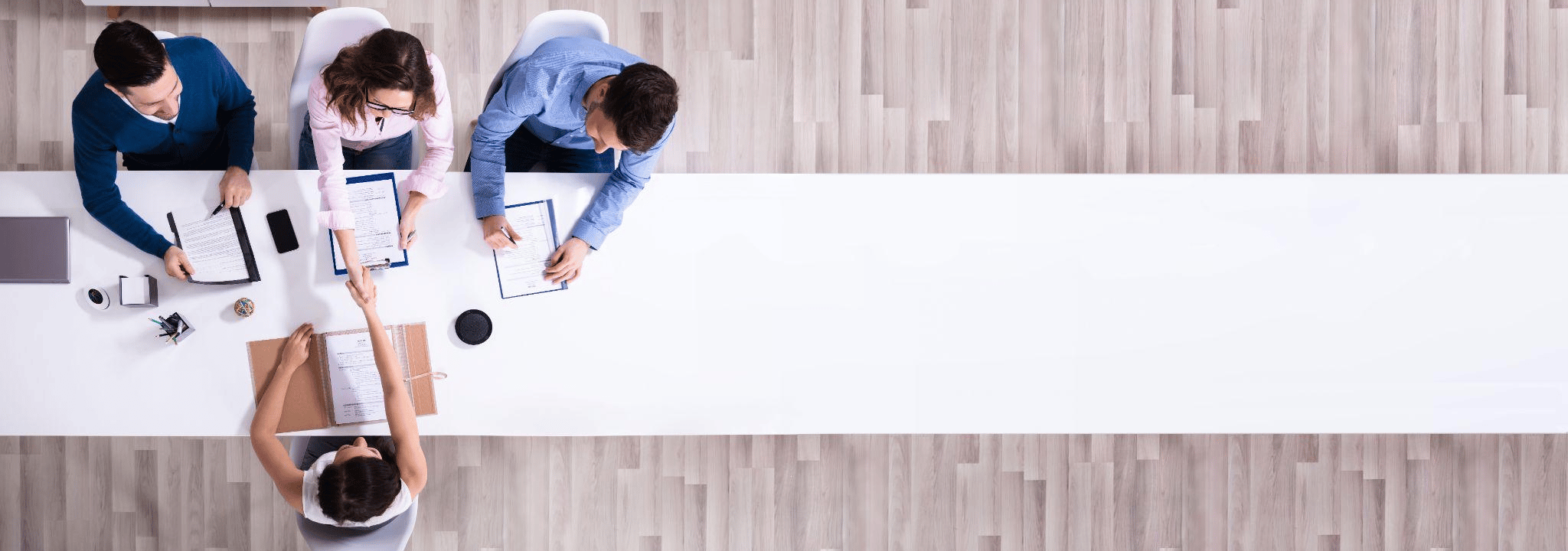 Birds eye view of an interview on a long white table